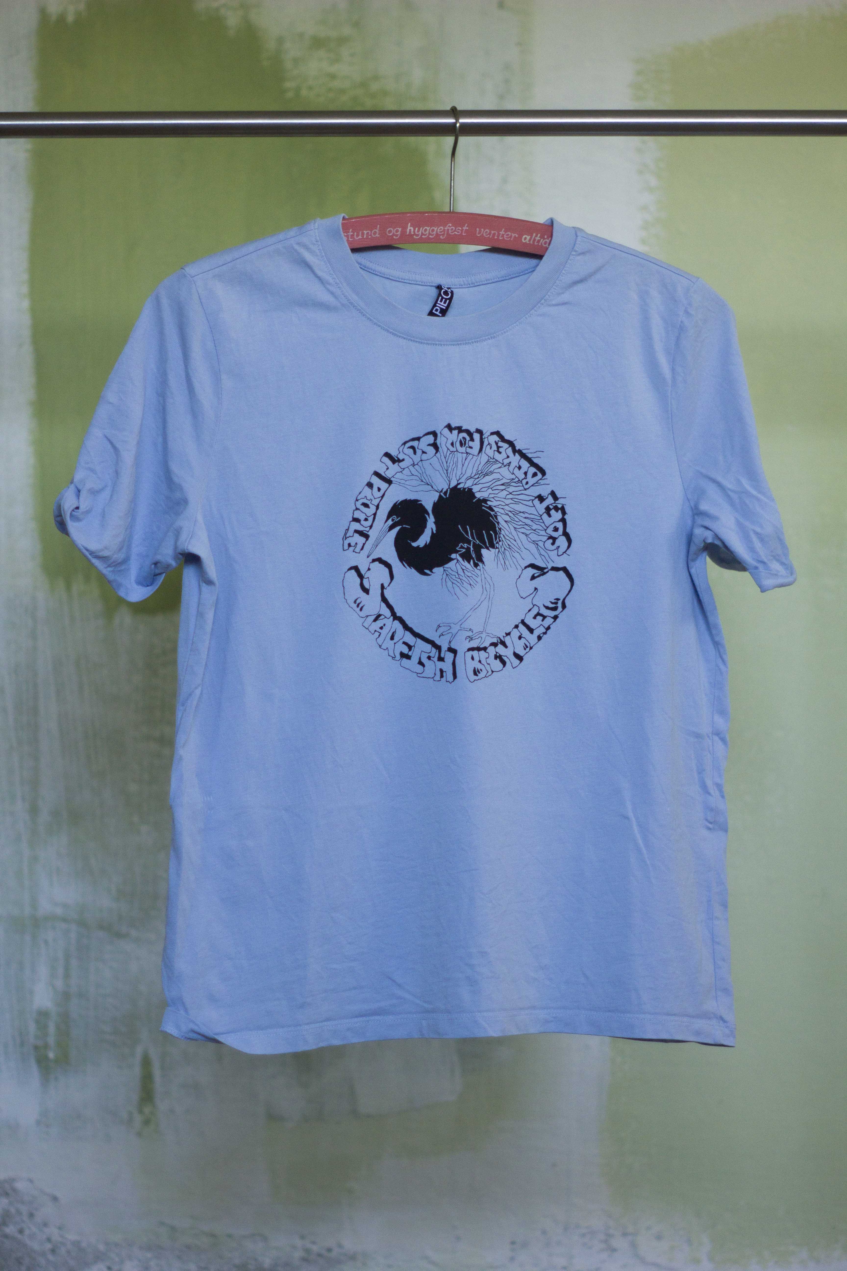 light blue t shirt with black print of hand drawn silver heron and the text 