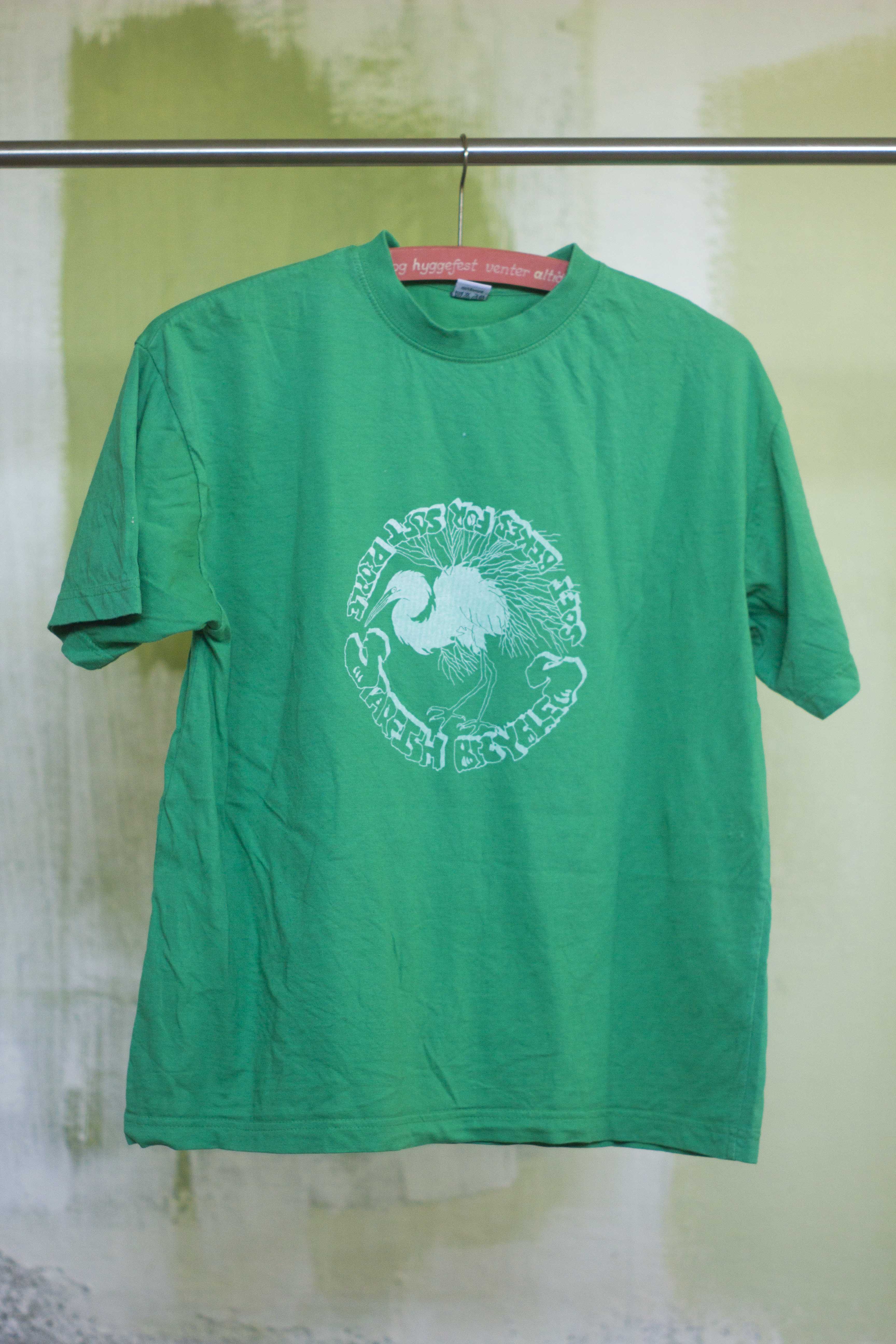 green t shirt with white print of hand drawn silver heron and the text 